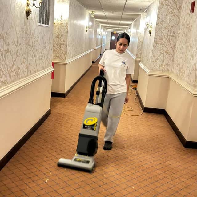 Vacuuming a long carpeted commercial corridor — MARTS-R.P Cleaning Solutions LLC