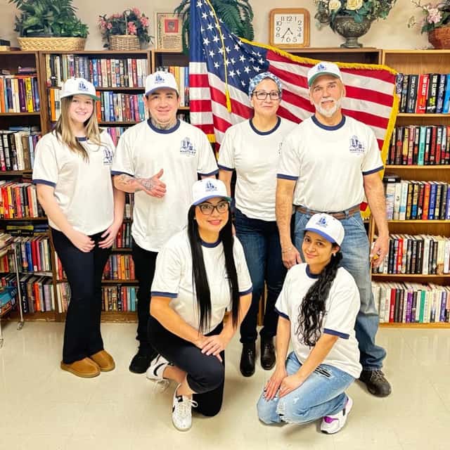 The full MARTS-R.P crew in uniform, standing in a library — MARTS-R.P Cleaning Solutions LLC
