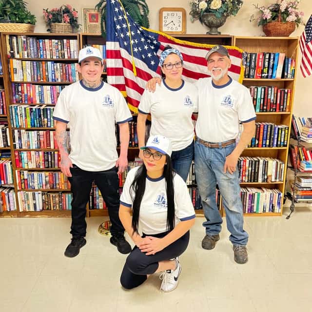 The crew lined up in uniform between the bookshelves — MARTS-R.P Cleaning Solutions LLC