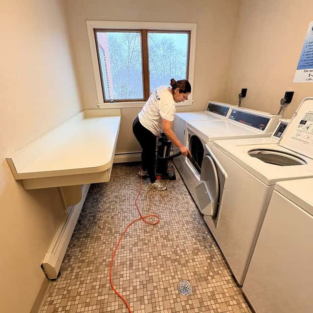 Wiping down the washers in a building laundry room — MARTS-R.P Cleaning Solutions LLC