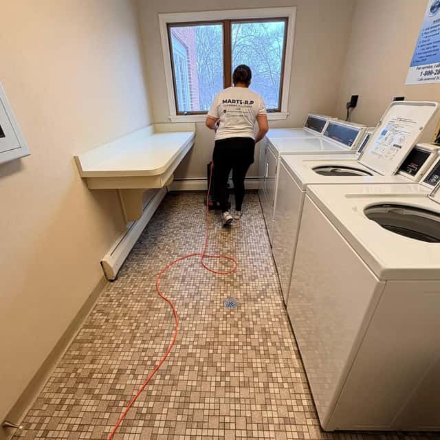 Vacuuming the floor of a laundry room — MARTS-R.P Cleaning Solutions LLC