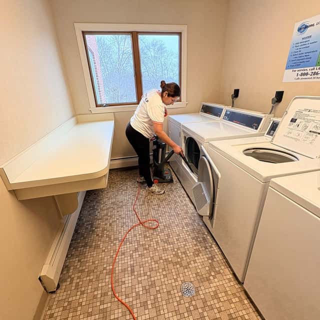Wiping the machines along a laundry room wall — MARTS-R.P Cleaning Solutions LLC