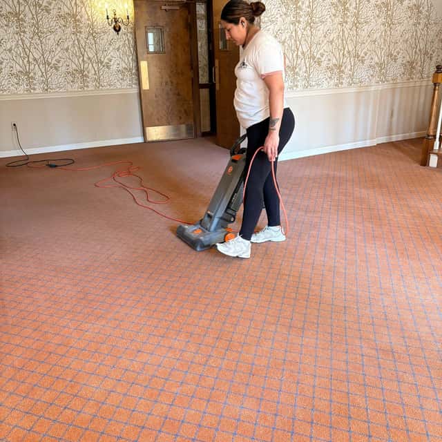 Vacuuming carpet in a wallpapered room — MARTS-R.P Cleaning Solutions LLC