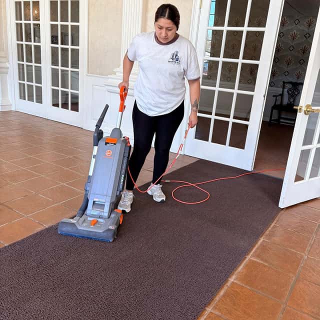 Vacuuming an entry mat beside French doors — MARTS-R.P Cleaning Solutions LLC